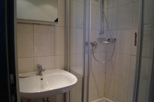 uma casa de banho com um lavatório e um chuveiro em Gästehaus Wagner em Egglfing