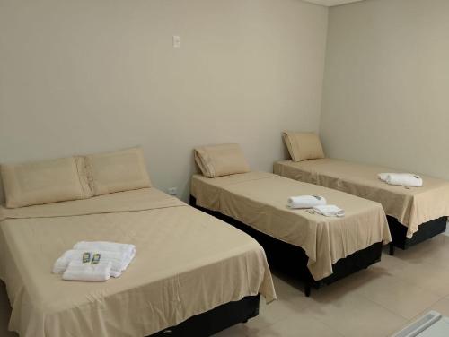 a room with three beds with towels on them at Chalé luar da serra, Camilos, Socorro in Socorro