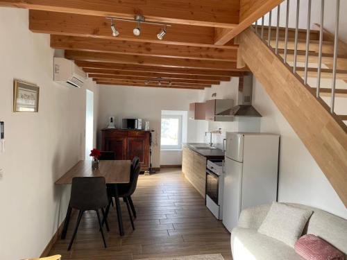 a kitchen and dining room with a staircase in a room at La Maison de Georgette in Versols-et-Lapeyre
