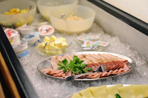 a plate of food on ice in a refrigerator at Alpinhotel Bort in Grindelwald