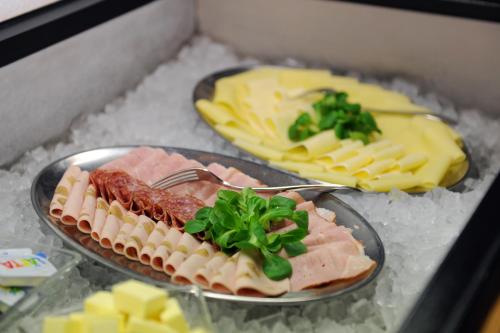 a plate of food with meat and cheese on a table at Alpinhotel Bort in Grindelwald