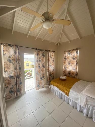 una camera da letto con un letto e un ventilatore a soffitto di Mango Tree House a Christ Church