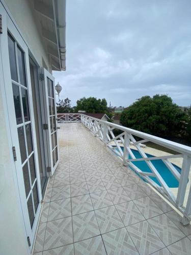 un balcone di un edificio con una ringhiera bianca di Mango Tree House a Christ Church