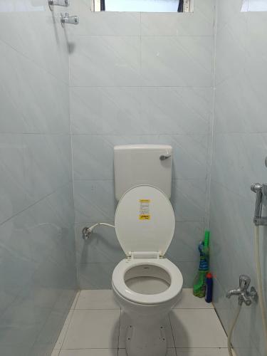 a bathroom with a white toilet and a shower at Jiya Mansion Guest house, Homestay in Guwahati