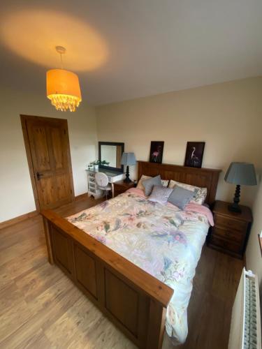 a bedroom with a large bed and a chandelier at Corrig View in Killenard