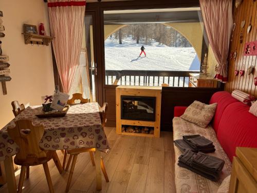 - un salon avec un canapé et une personne skier dans la neige dans l'établissement Evasion Unique Ski au Pieds, à Montgenèvre