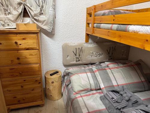 une chambre avec un lit et une commode en bois dans l'établissement Evasion Unique Ski au Pieds, à Montgenèvre