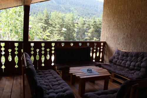 a screened in porch with couches and a coffee table at Hotel Eden in Mestia