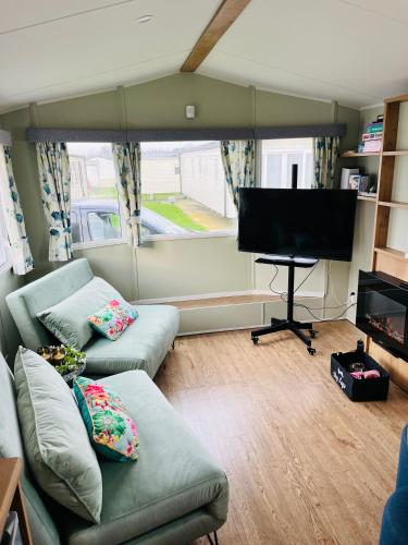 a living room with a couch and a flat screen tv at KEE Holiday Home Caravan in Great Yarmouth