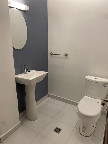 a bathroom with a white toilet and a sink at Résidence hôtelière MEDOM Palace, Bastos in Yaoundé