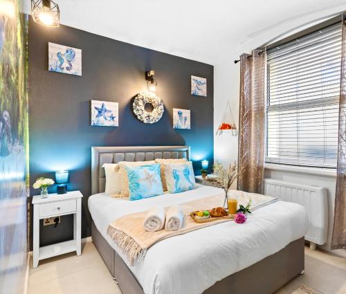 Stylish 1-Bedroom Apartment near Beach - Brighton في برايتون أند هوف: غرفة نوم بها سرير عليه صينية طعام
