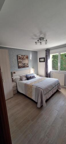 a bedroom with a large bed and a window at Chambre et petit déjeuner à Socoa in Urrugne