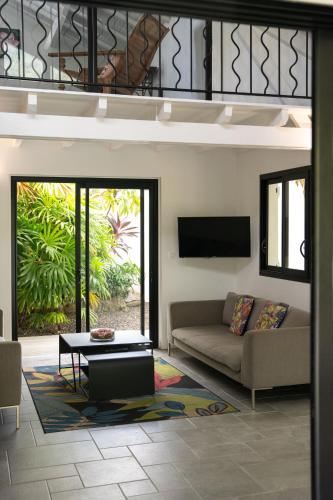 a living room with a couch and a table at Domaine de la Palmeraie - Villas Lodge in Le Diamant