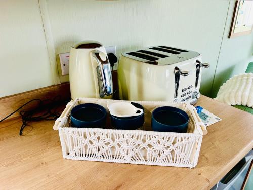 a tray of cups sitting on a counter next to a toaster at KEE Holiday Home Caravan in Great Yarmouth