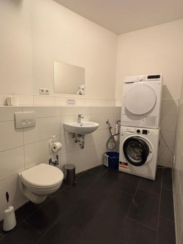 a bathroom with a washing machine and a sink at Case Four Boardinghouse mit Parkplatz, Küche, Waschmaschine und Trockner in Marl