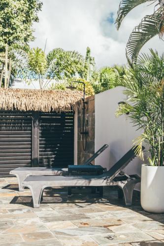 a patio with a bench and a building at Domaine de la Palmeraie - Villas Lodge in Le Diamant
