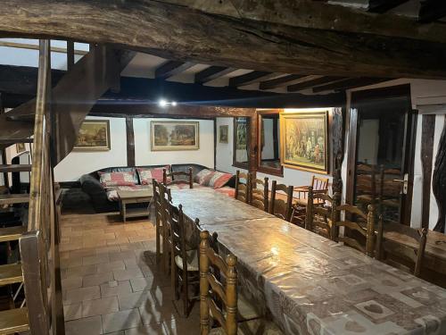 Una sala de estar con una gran mesa y sillas de madera. en DOMAINE DU BOIS L'ABBE, en Épaignes