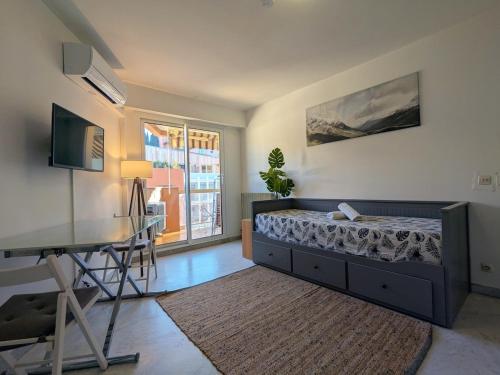 Un dormitorio con una cama, una mesa y un escritorio. en Vue dégagée, emplacement idéal, climatisé, en Menton