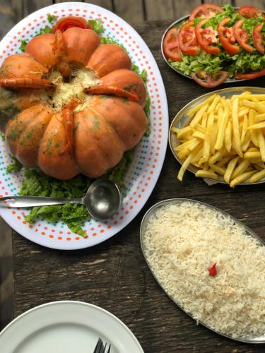 a table with plates of food with a turkey and french fries at Banana Leaf Eco Hostel in Barra de Guaratiba