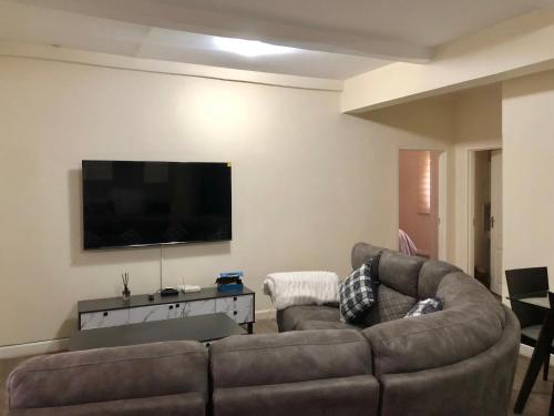 a living room with a couch and a flat screen tv at Serviced 2 Bedroom in Long Acres in Lusaka