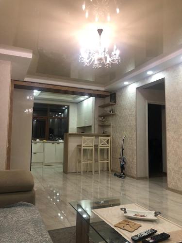 a living room with a couch and a chandelier at Tbilisi Sea Apartments in Tbilisi City
