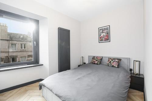 a white bedroom with a bed and a window at Traditional 1-Bed Edinburgh Apt in Edinburgh