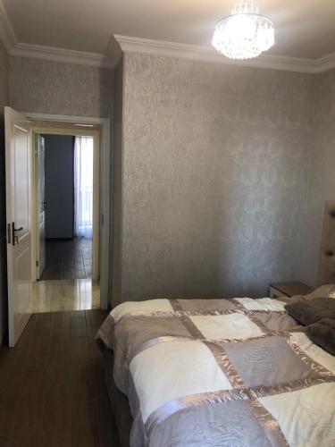 a bedroom with a bed and a chandelier at Tbilisi Sea Apartments in Tbilisi City