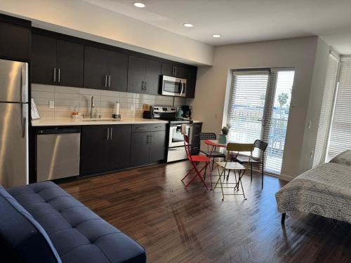 a kitchen with black cabinets and a table and chairs at Incredible Hollywood Loft Free Parking in Los Angeles