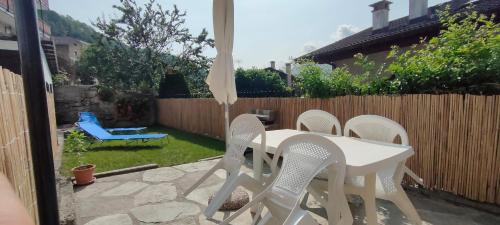 a white table and chairs in a backyard at alloggio in centro con giardino in Sampeire