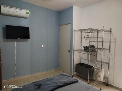 Zimmer mit einem Schlafzimmer mit einem Bett und einem TV in der Unterkunft Depa totalmente climatizado y tranquilo in Valente Díaz y La Loma