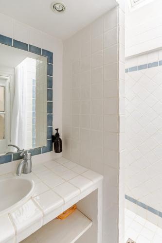 une salle de bain blanche avec un lavabo et un miroir dans l'établissement La Cabine - cœur de Honfleur - vue imprenable, à Honfleur