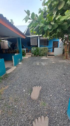 a building with a yard with a pair of shoes on the ground at Hostal Niña Oly in Tamanique