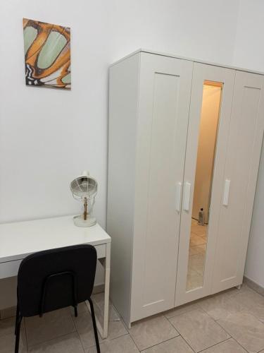 a white desk with a chair next to a white cabinet at Le Shamma lodge in Reims
