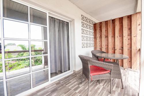 a room with a table and chairs and a window at Kuti Apartments in Abeokuta