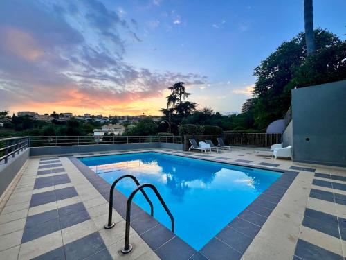 une piscine avec un coucher de soleil en arrière-plan dans l'établissement Le Cap - Pool and Amazing sea view, à Nice