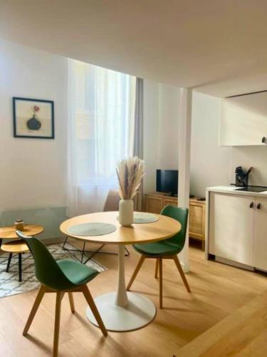 - un salon avec une table et des chaises vertes dans l'établissement Studio de charme au centre de Montpellier!, à Montpellier