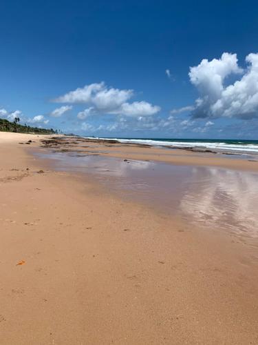 a sandy beach with clouds in the sky at Cabana Sabiá in Camaçari