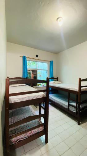 a room with three bunk beds and a window at Hostel Familiar in Salvador