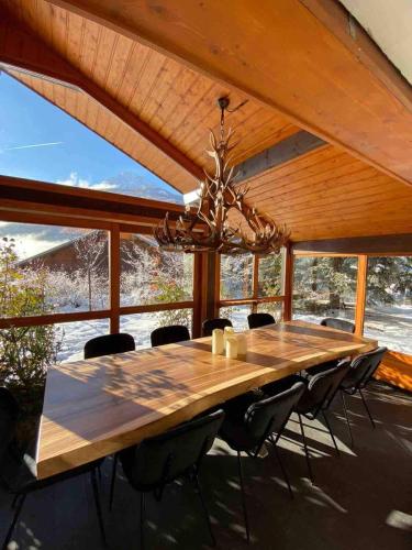 une table à manger avec des chaises et un lustre dans l'établissement Maison Amore Serre Chevalier, à Saint-Chaffrey