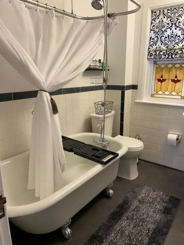un bagno bianco con vasca e WC di Historic Downtown-families & groups! ADA approved a Gettysburg