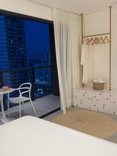 a bedroom with a bed and a table and a window at IorubaStudio in Salvador