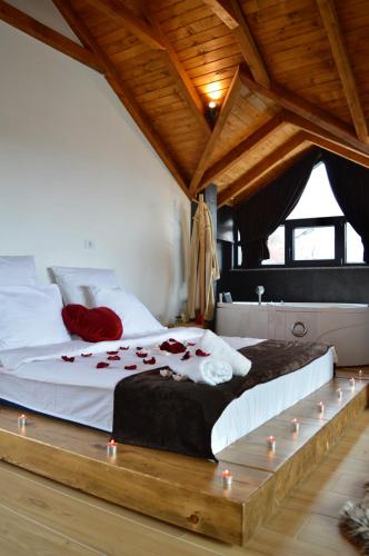 a bedroom with a large bed with candles on it at Ren Villas in Mavrovo
