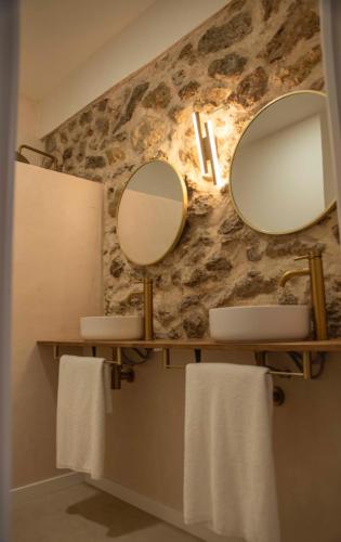 a bathroom with two sinks and two mirrors on the wall at Ribazos de la Sierra in Carmona