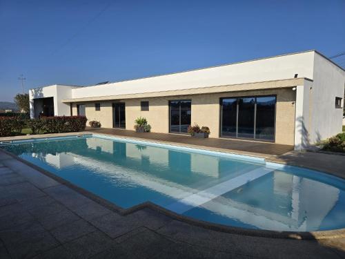 a swimming pool in front of a building at Petit Maison in Além da Ribeira