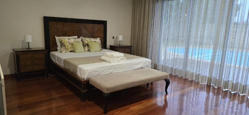 a bedroom with a bed and a large window at Petit Maison in Além da Ribeira