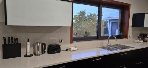 a kitchen counter with a sink and a window at Petit Maison in Além da Ribeira