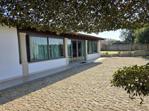 a building with windows and a brick driveway at Petit Maison in Além da Ribeira