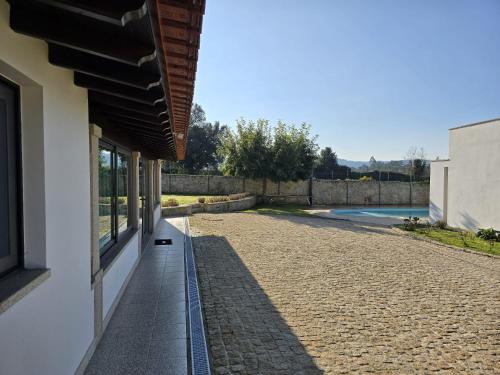 a house with a stone walkway next to a building at Petit Maison in Além da Ribeira