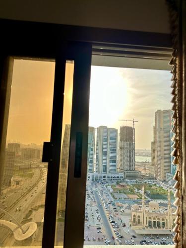a view of a city skyline from a window at Entire 1-Bedroom Apartment with Balcony, Sharjah in Sharjah