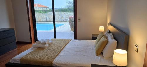 a bedroom with a bed with a view of a pool at Petit Maison in Além da Ribeira